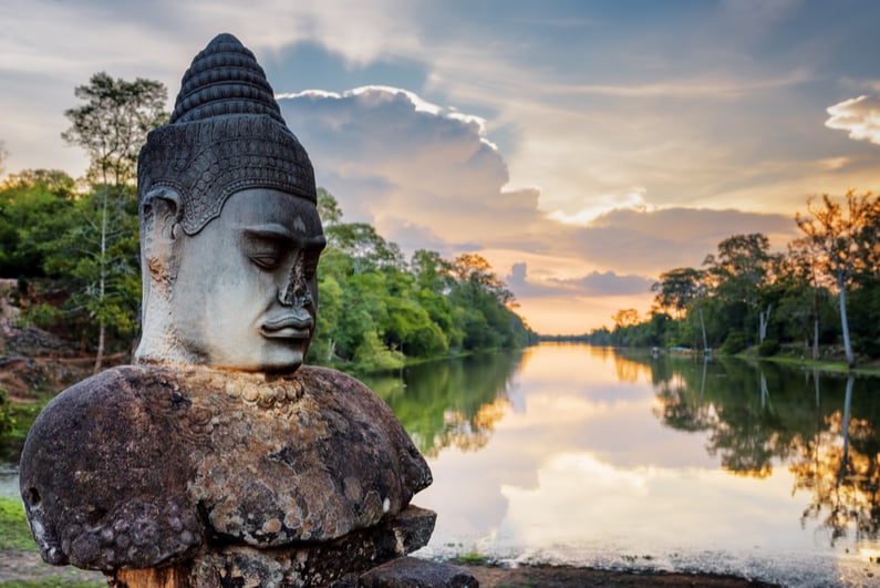 Stone asura in foreground, Cambodian sunset in background