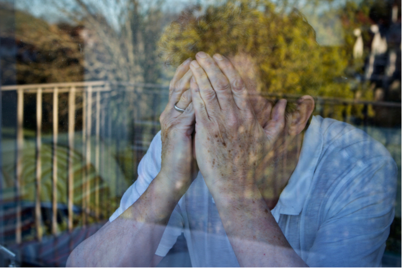 Despondent man with head in hands