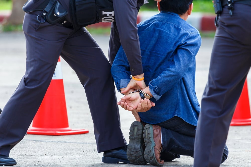 man being handcuffed by a police officer