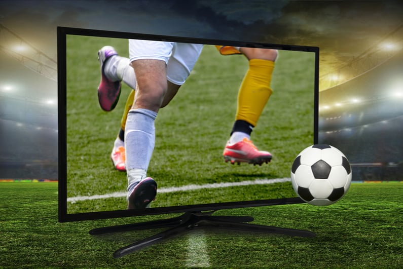 Soccer players and ball coming out of a TV