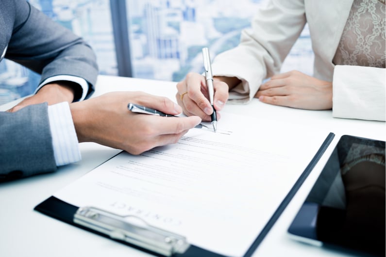 two businesspeople signing a contract