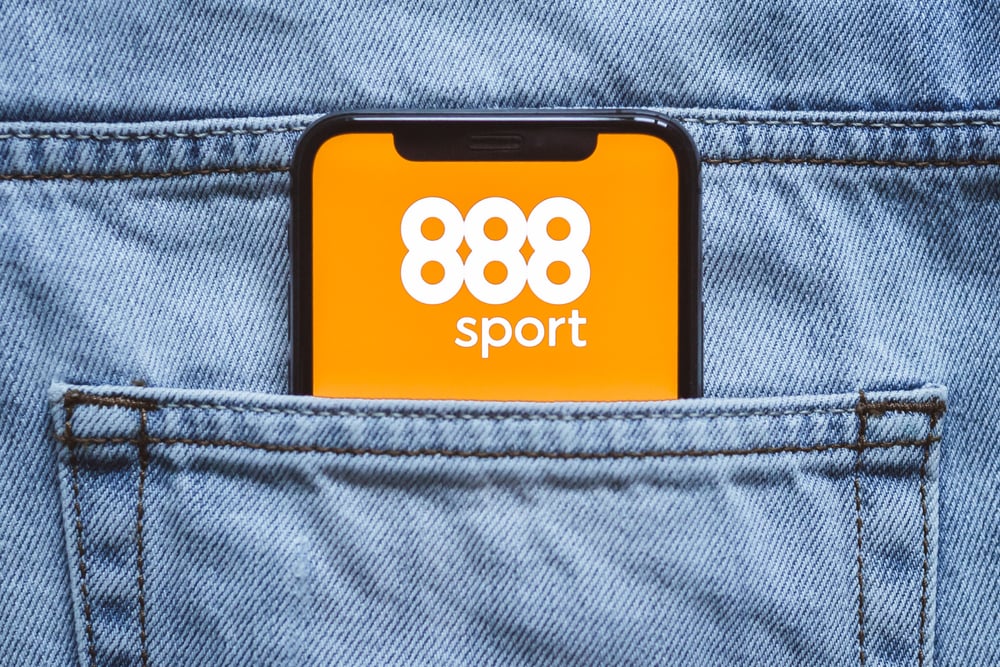 Smartphone inside jeans back pocket sporting the 888Sport logo