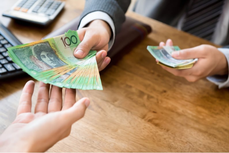 Businessman handing over Australian cash